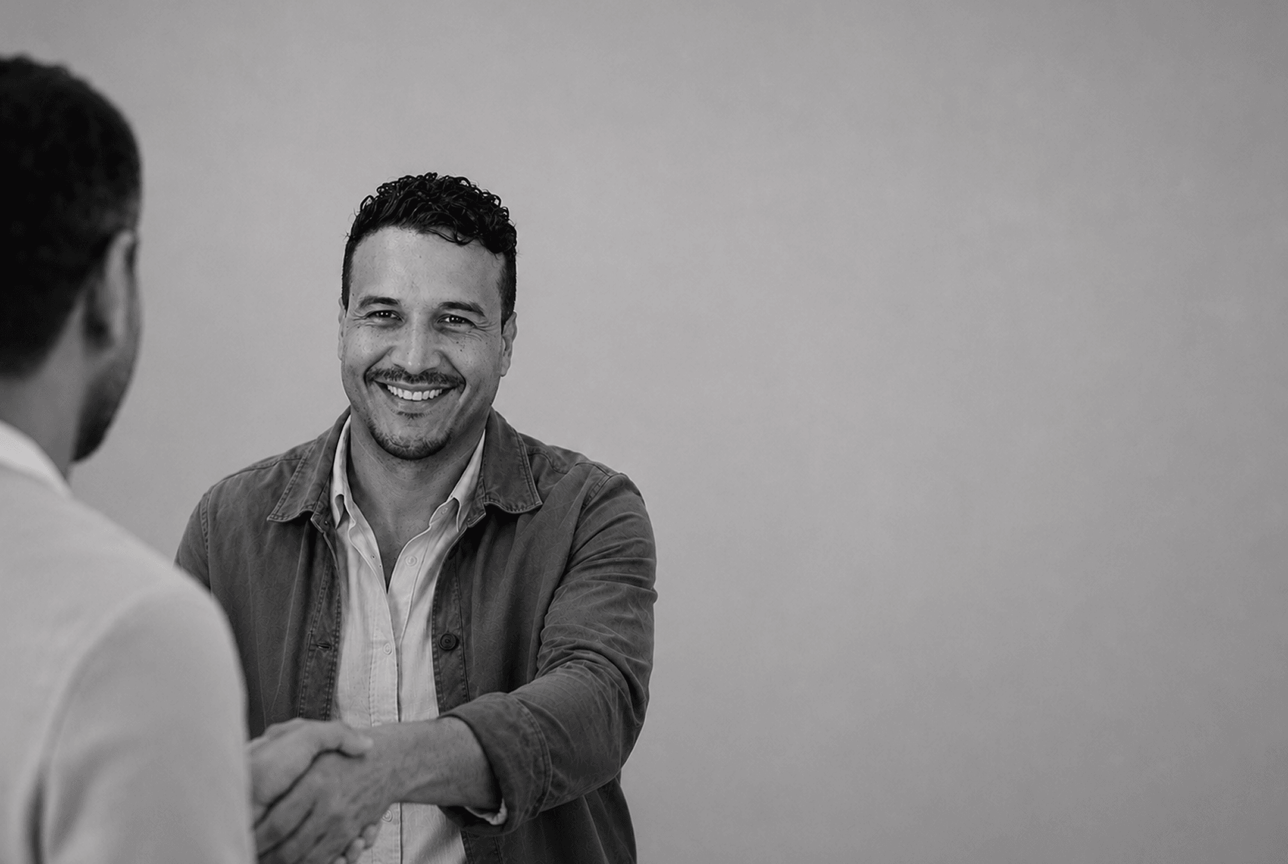 Mario Rivera, founder of Netneo, shaking hands with a client after closing a project in Oviedo